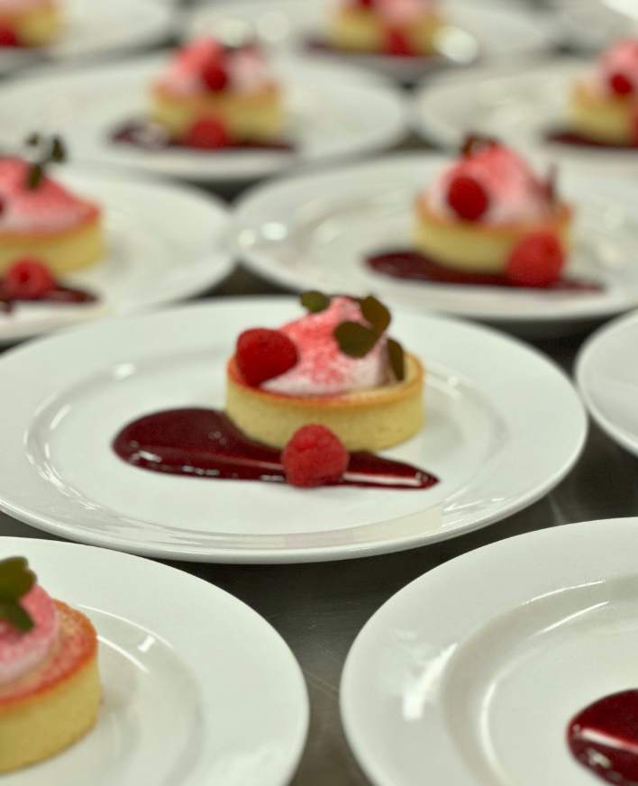Økologisk dessertanretning med tærte, hindbær og flødetop