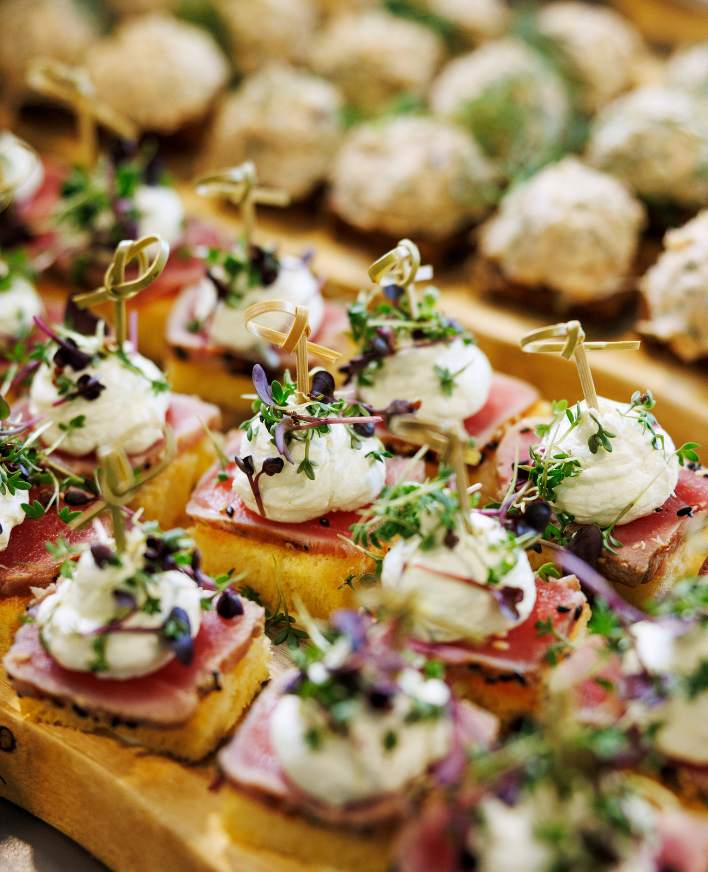 Fingerfood på træfad med krydderurter og spiselig pynt
