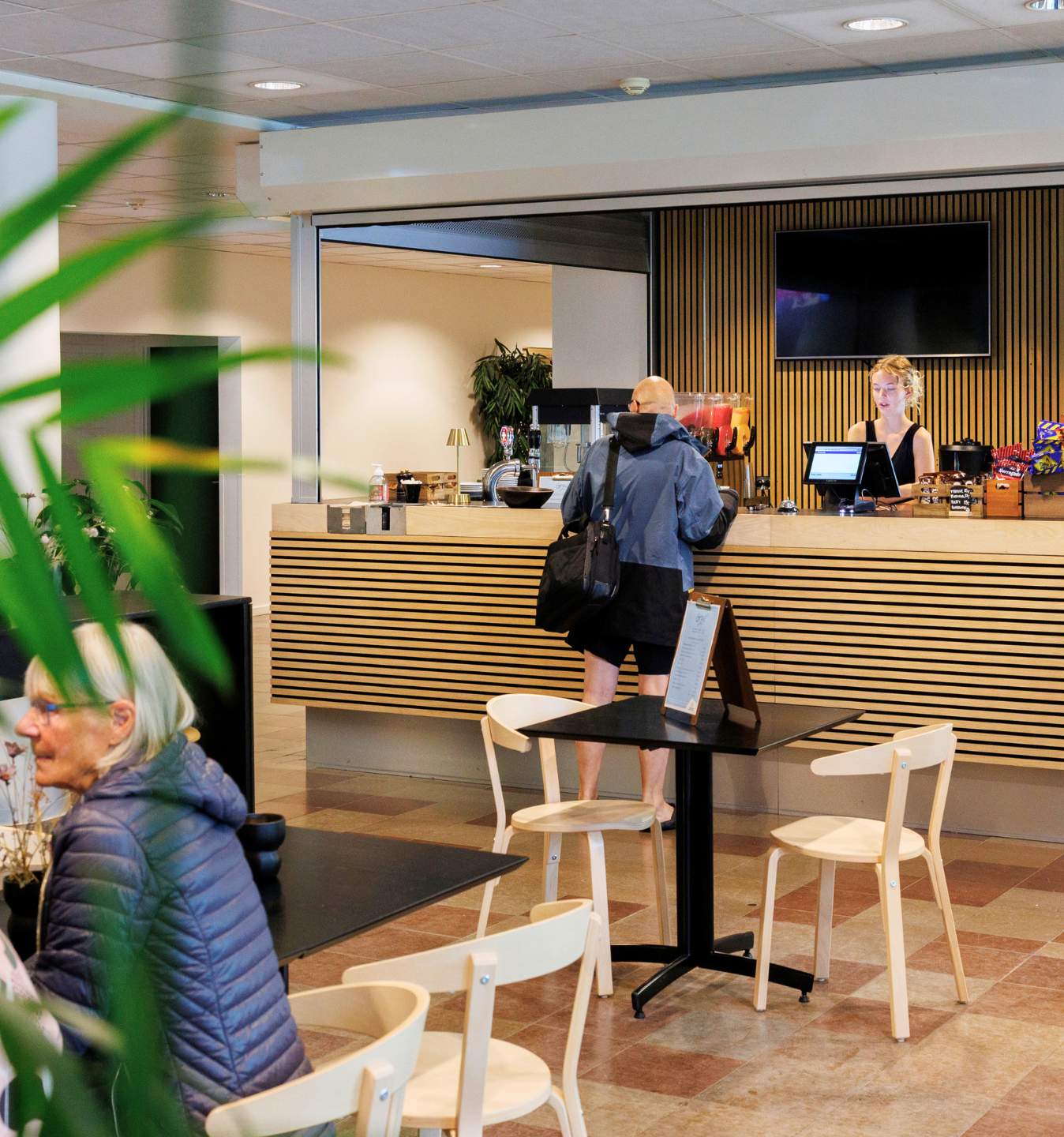 Gæst bestiller mad og drikke i Café Gro